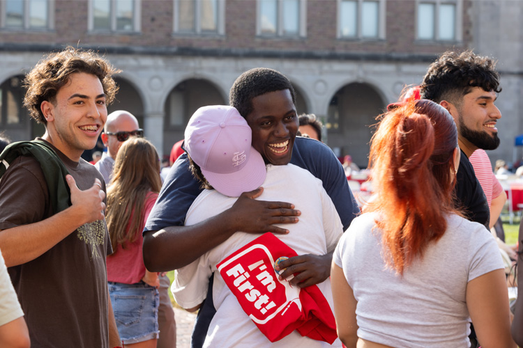 students hugging and laughing on campus