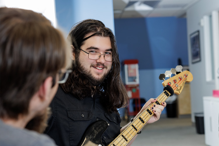 student plays guitar in the TFCSS